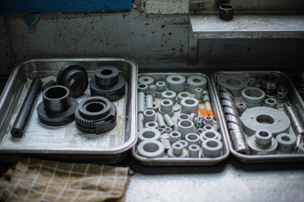 Steel turned parts in three trays showing black oxide, nitrided and untreated machined surface finishes side by side for comparison